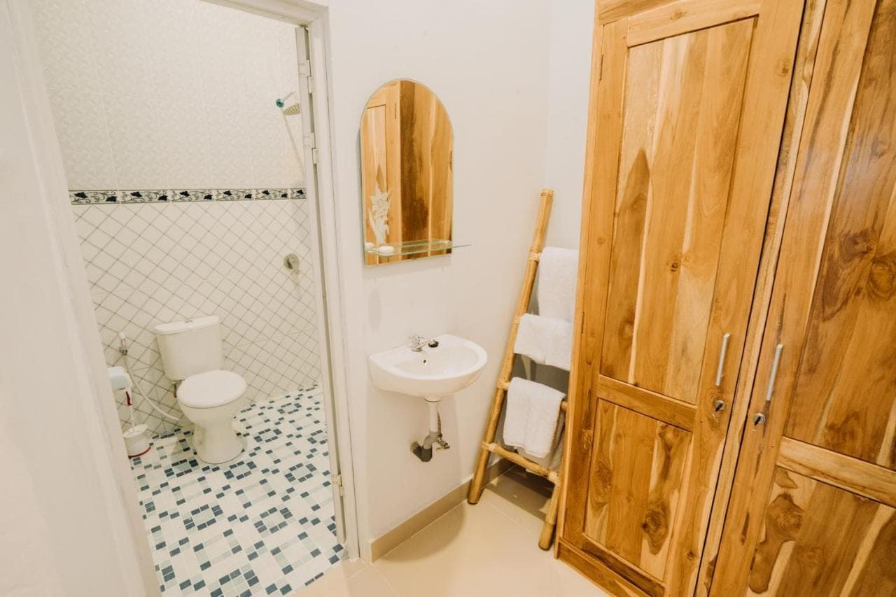 a bathroom with a sink and a toilet and a shower at Nova Guest House in Canggu