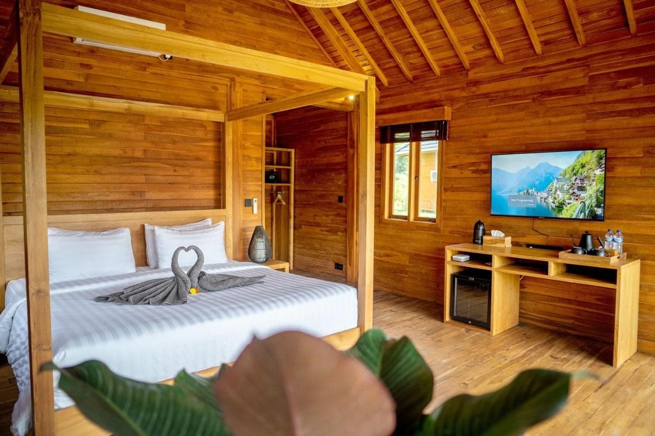 a bedroom with a bed and a tv in a room at Taman Swarga Villa Resort & Spa Sidemen in Sidemen