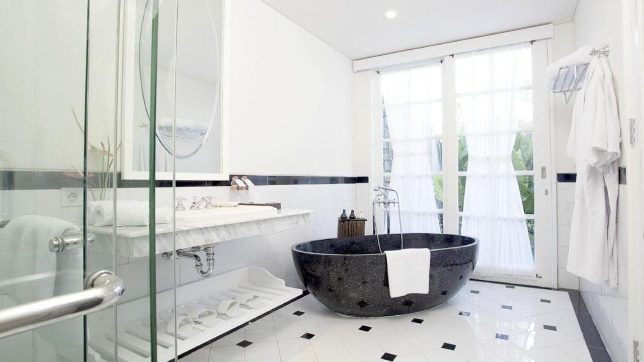 a bathroom with a large tub and a sink at SOLTERRA SEMINYAK Boutique Hotel & Spa Powered by Archipelago in Seminyak