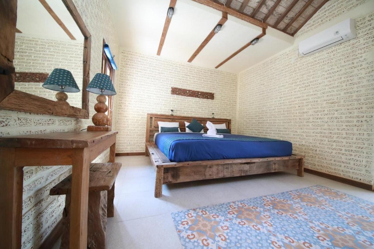 a bedroom with a bed and a desk in a room at Mango Villa in Amed