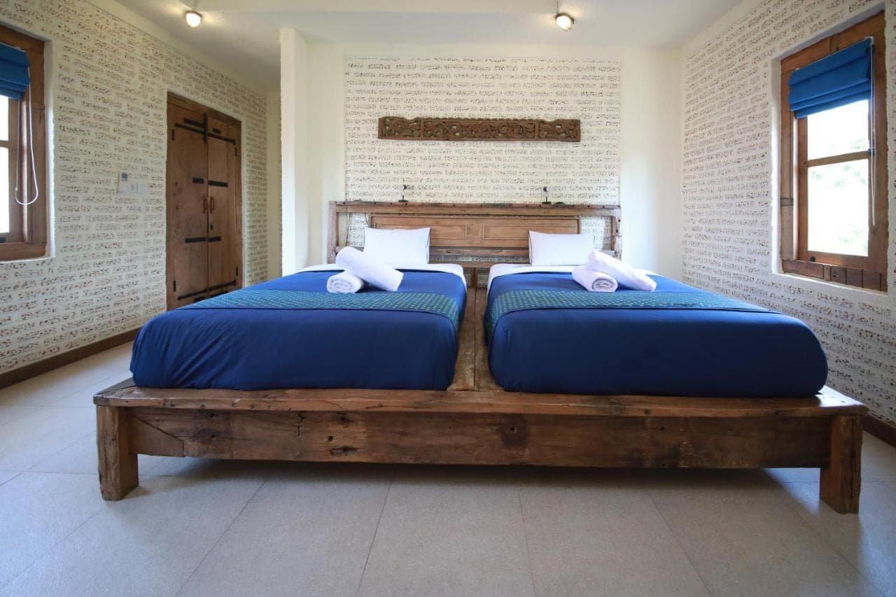 two beds sitting on a wooden table in a room at Mango Villa in Amed