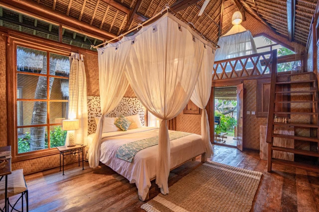 a bedroom with a bed with a canopy at Santai Hotel in Amed