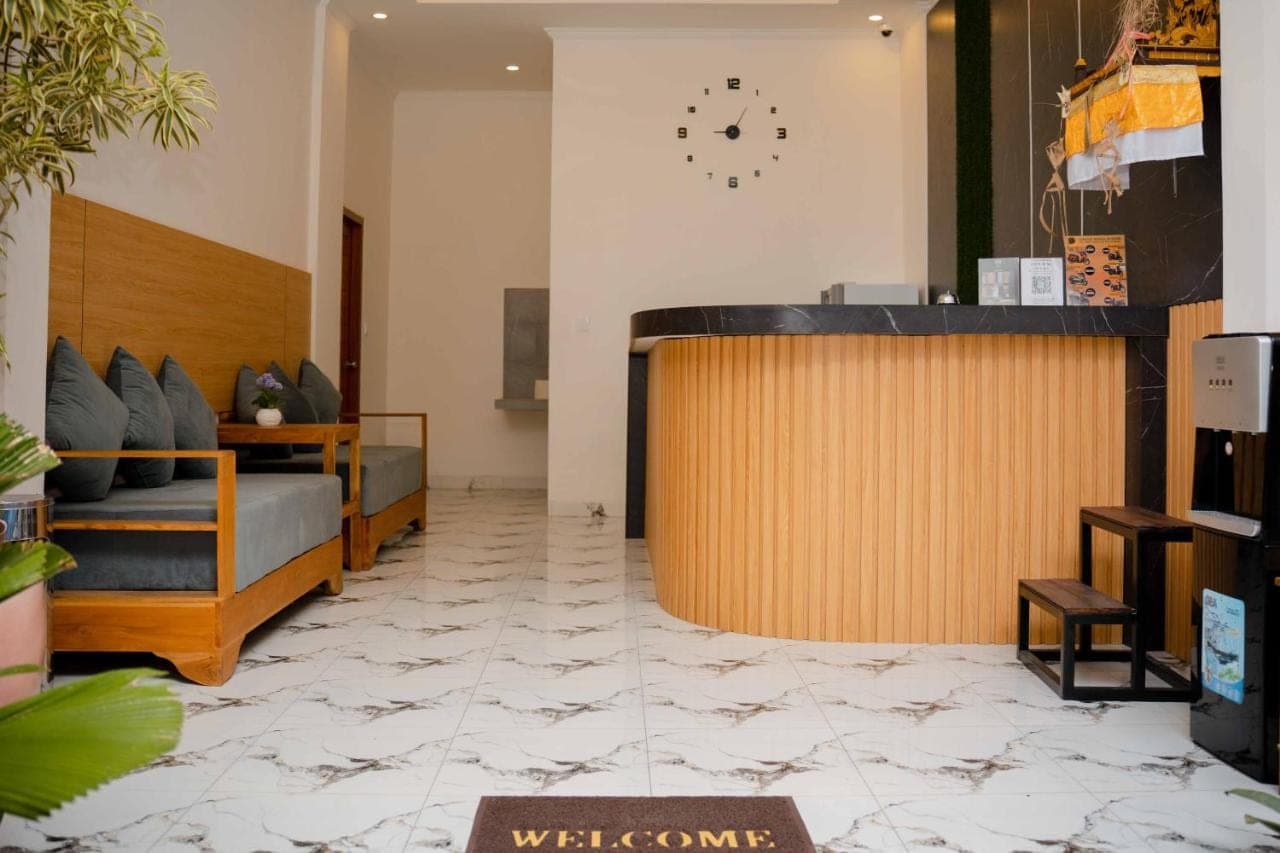 a lobby with a reception desk and a clock on the wall at La Tano's Canggu in Canggu