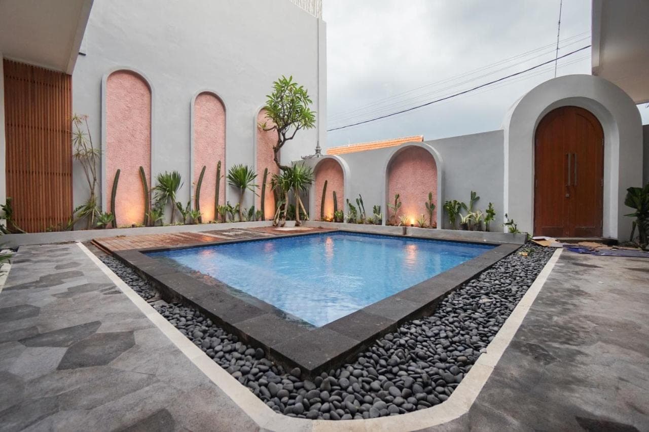 a pool in the middle of a building with rocks around it at La Tano's Canggu in Canggu
