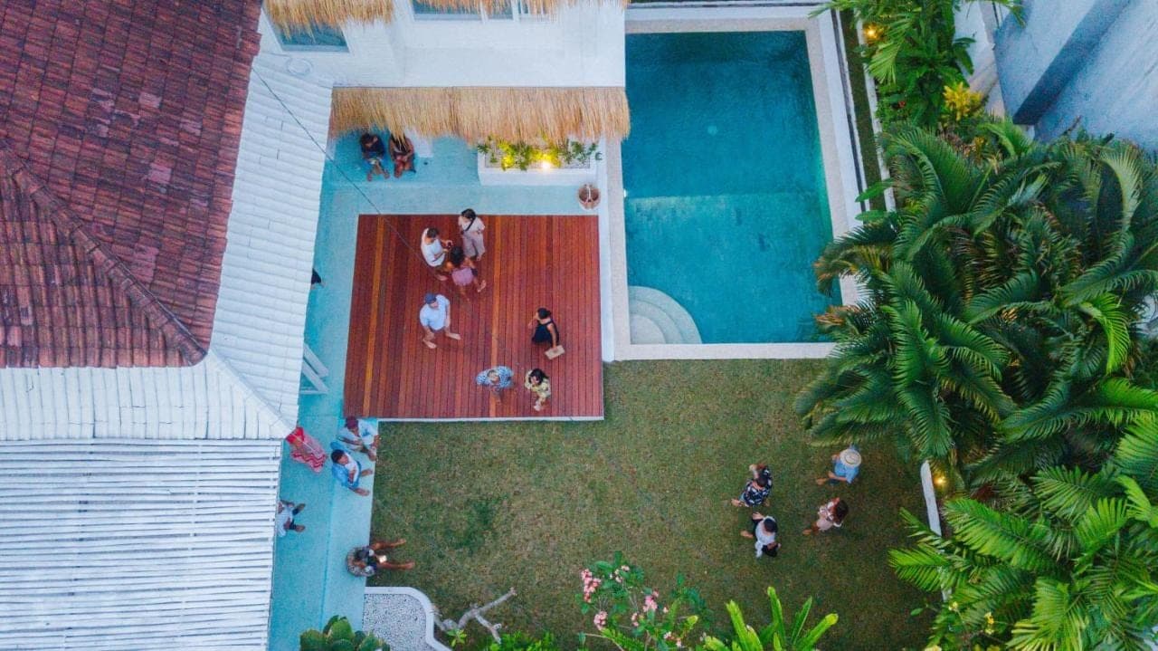an overhead view of a swimming pool with people standing around it at Guru Canggu Art Hotel in Canggu