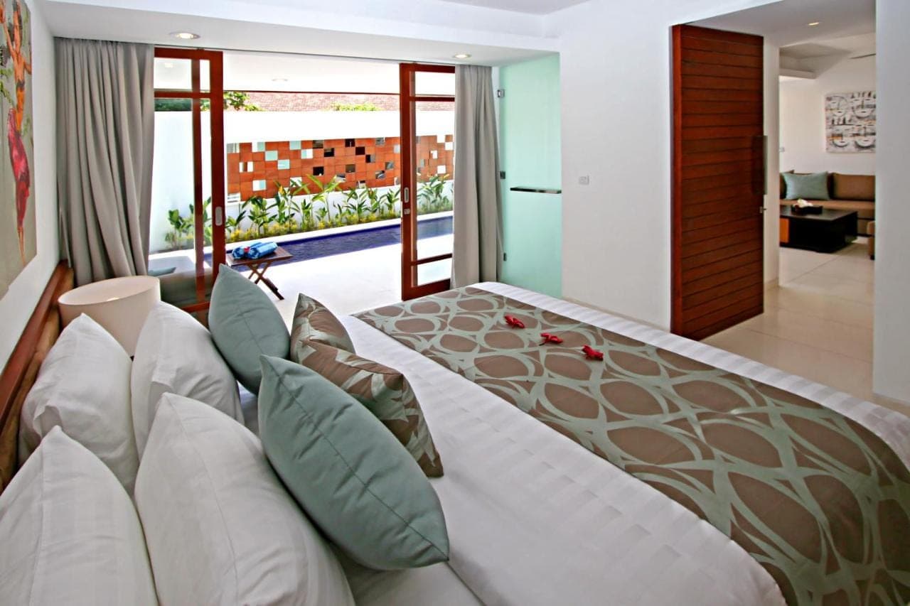 a bedroom with a large bed with pillows at Smart Comfort Apartments in Sanur