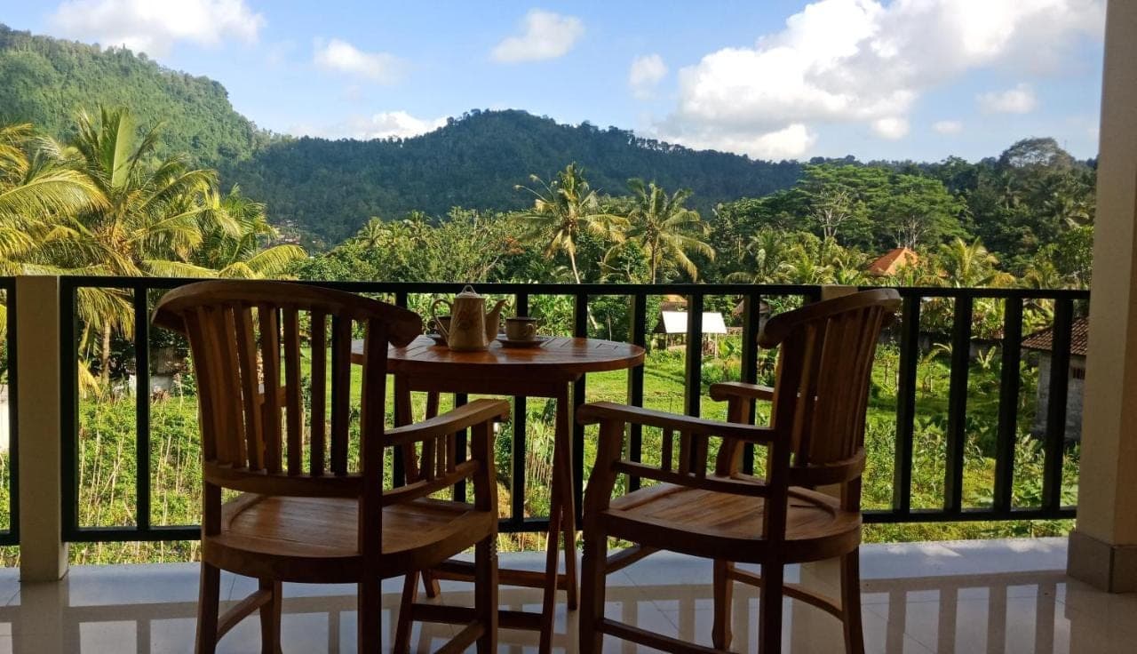 a table and two chairs on a balcony with a view at Mantra Guesthouse Sidemen in Sidemen