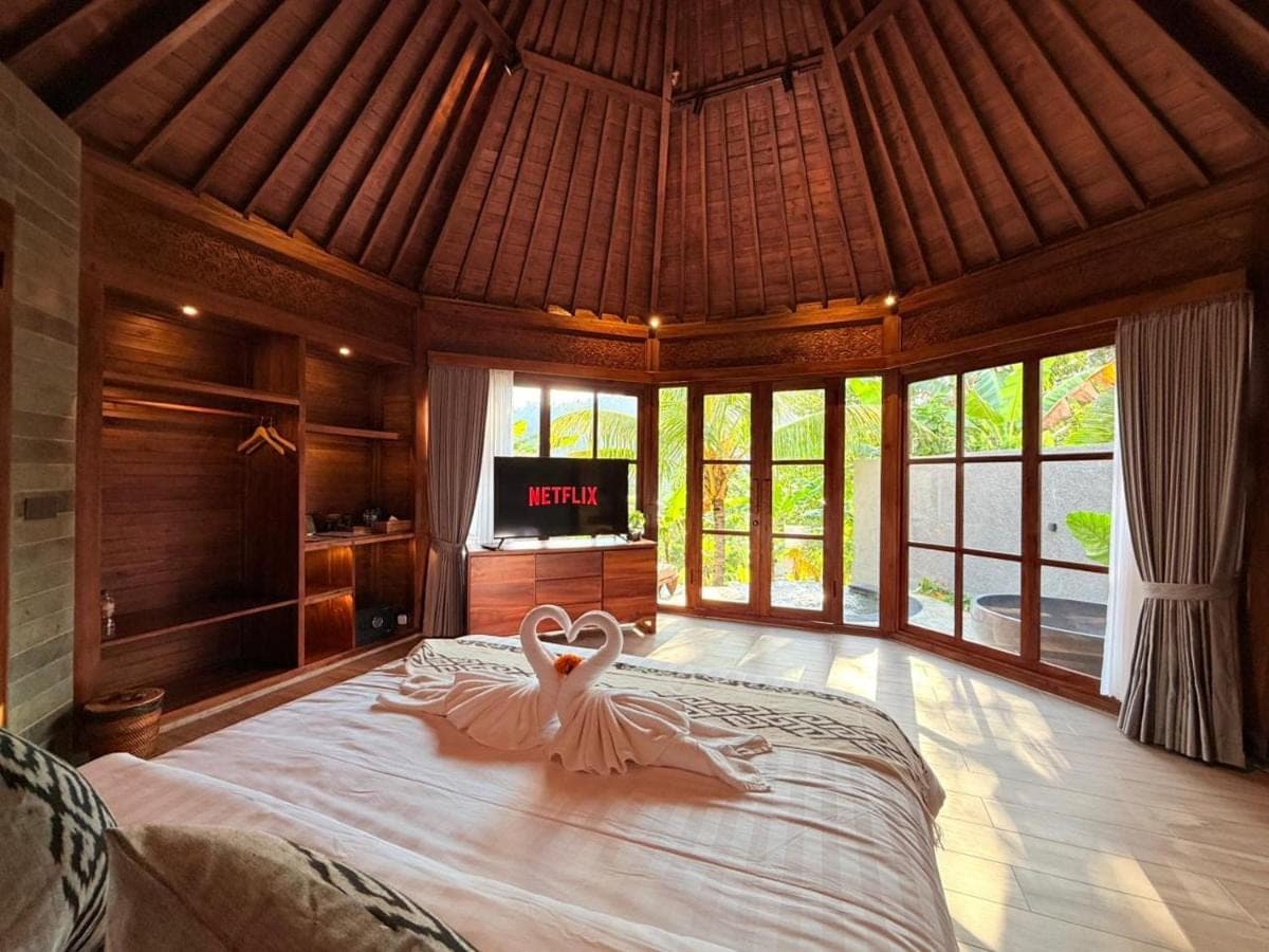 a room with a bed with a dress on it at Wanataru Sidemen Villas in Sidemen