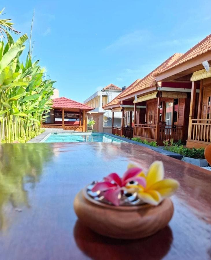 a resort swimming pool with a bowl with flowers on it at Pondok Denly by Pigeon in Nusa Dua