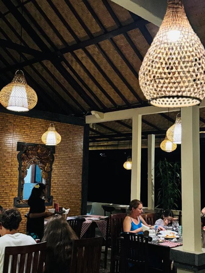 people sitting at tables in a restaurant with lights at Deva Graha Sidemen in Sidemen