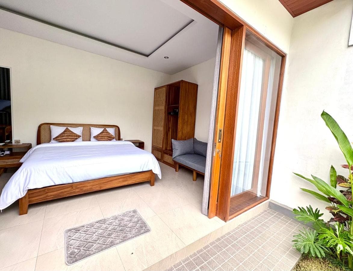 a bedroom with a bed and a window at Mahayasa Hidden Retreats 1BR Garden Villa in Canggu
