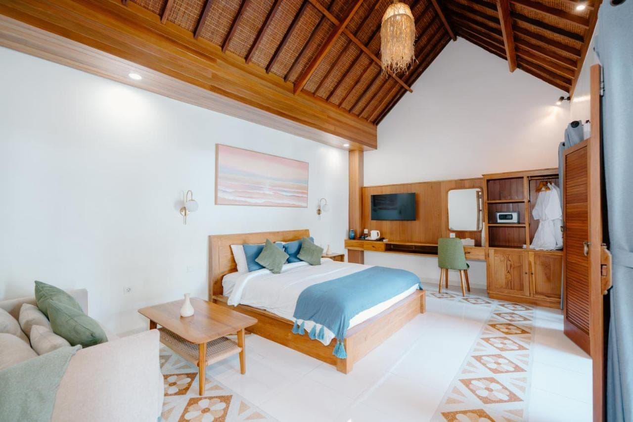 a bedroom with a bed and a couch at Kania Rooms & Suite Legian in Seminyak