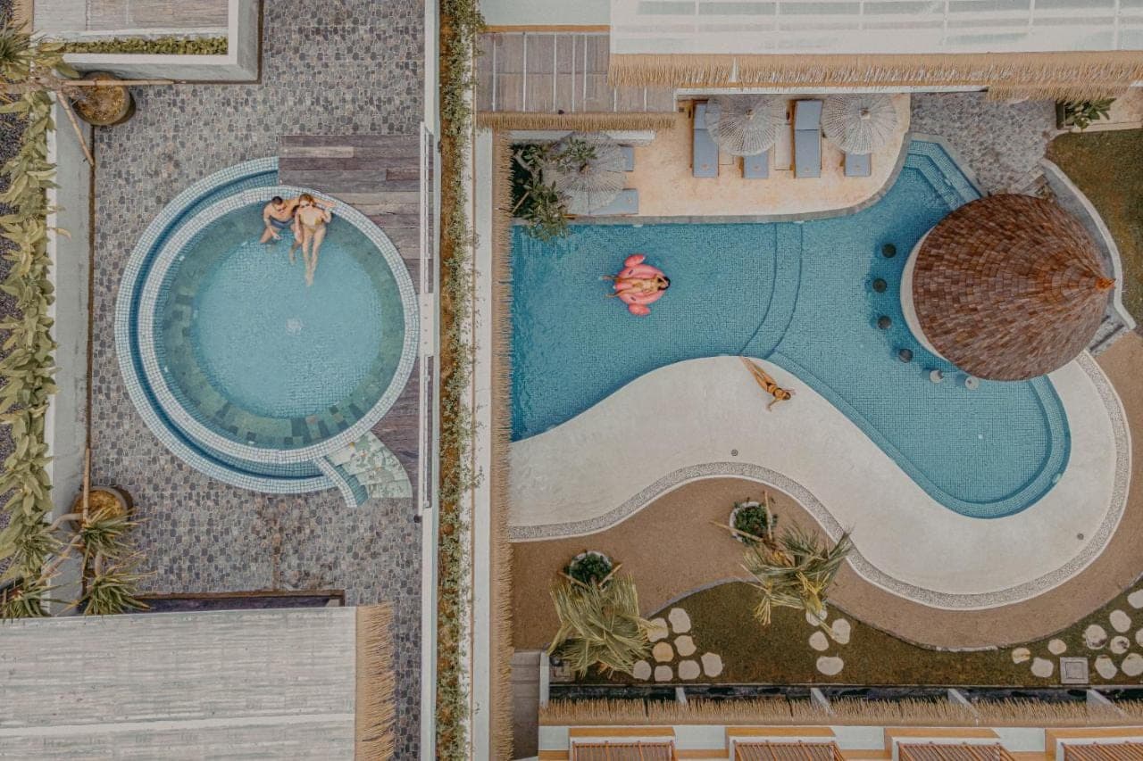 a painting of a swimming pool with two people in it at Roomates Beach Hostel Canggu by Ini Vie Hospitality in Canggu
