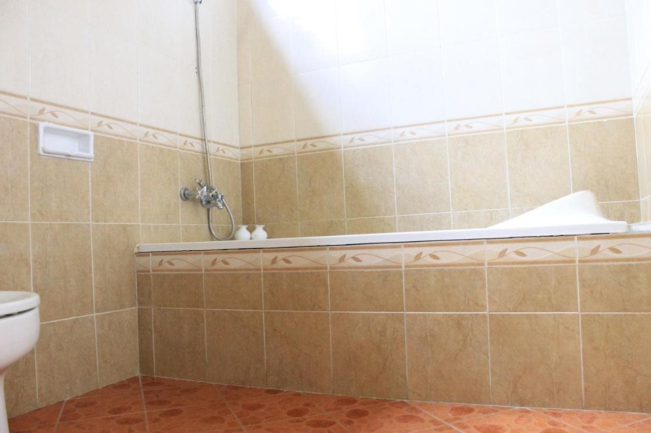 a bathroom with a tub and a toilet at Tanah Semujan Ubud in Ubud