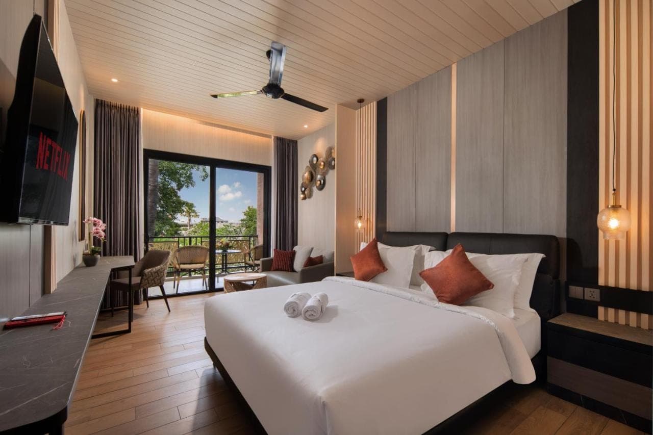a bedroom with a large white bed and a living room at Amankara Canggu in Canggu