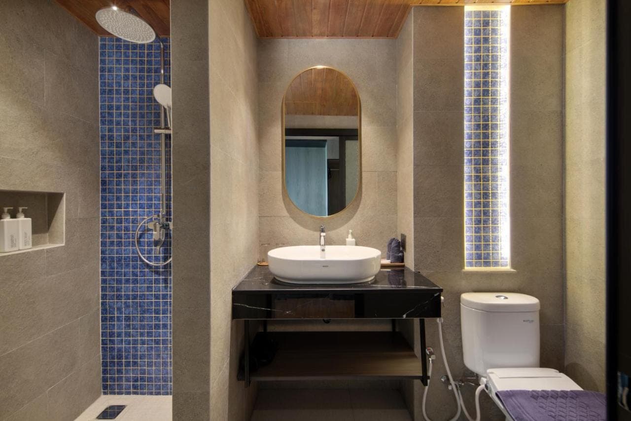 a bathroom with a sink and a mirror and a toilet at Amankara Canggu in Canggu