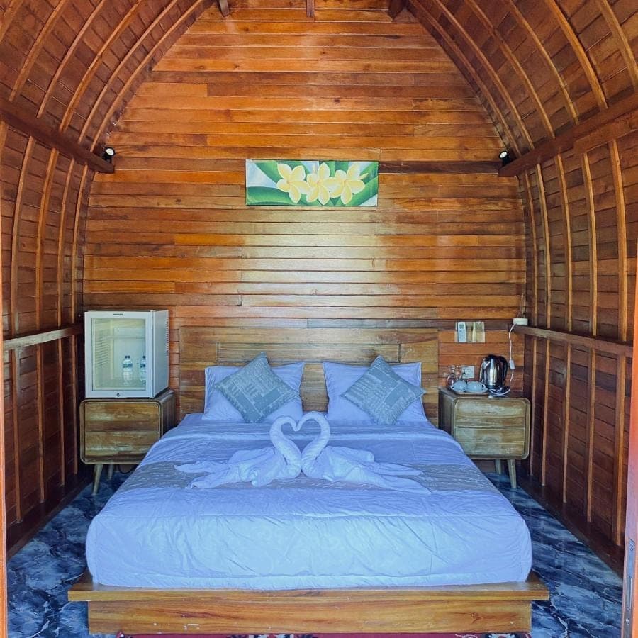 a bedroom with a bed in a wooden room at Pondok Taksu Homestay Sidemen in Sidemen