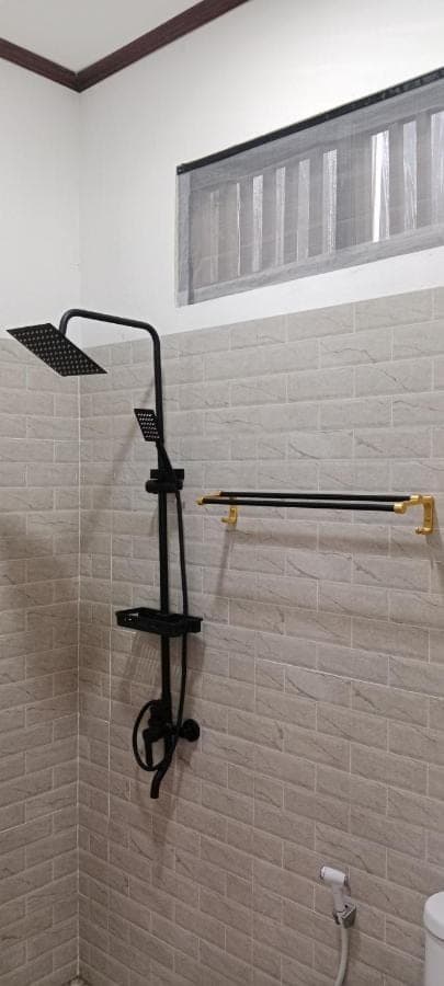 a bathroom with a shower with a glass wall at Beten Enjung Home Stay&rooftop in Amed