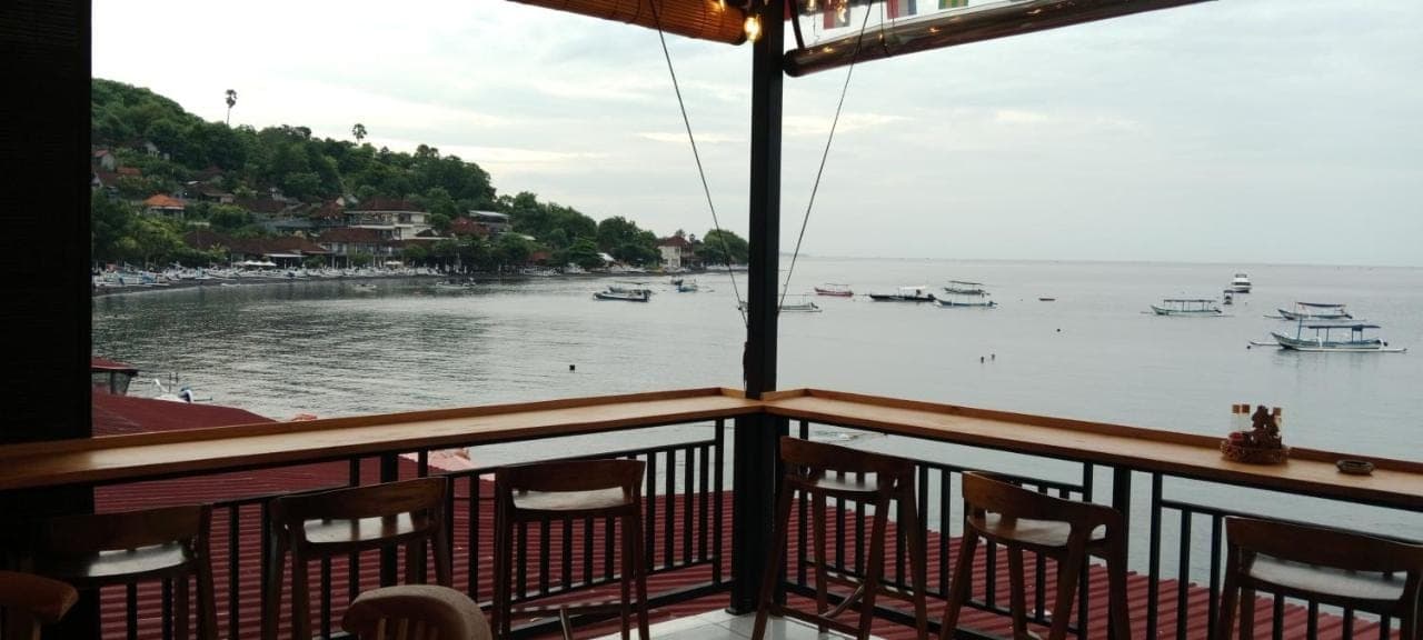 a view of the water from a balcony of a boat at Beten Enjung Home Stay&rooftop in Amed