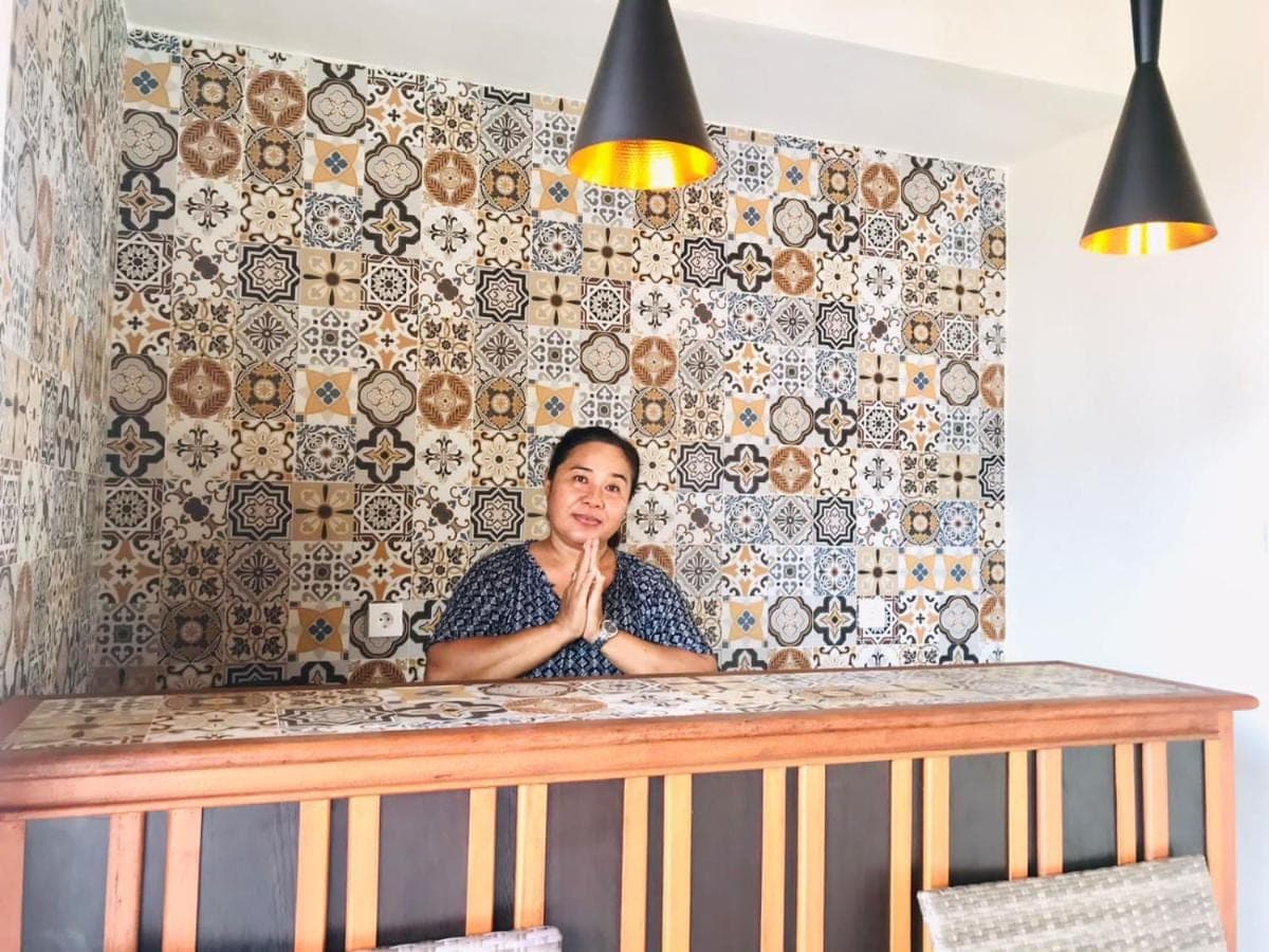 a woman sitting at a counter in front of a wall at Londo House in Ubud